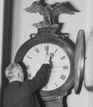 A senator changing the time on a clock.
