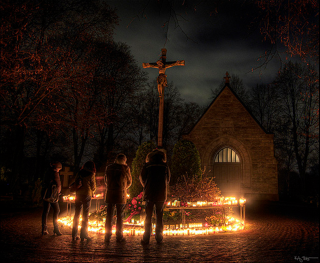 Christians pray and place candles and flowers on the graves of their loved ones on All Hallows Eve.